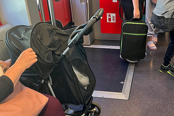 Kinderwagen und Koffer im Zug