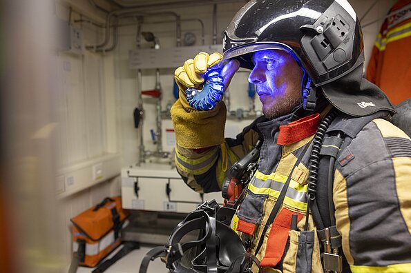 Ein Feuerwehrmann mit einem blauen Blinklicht: Es wird im Tunnel über Löschwasser informieren.