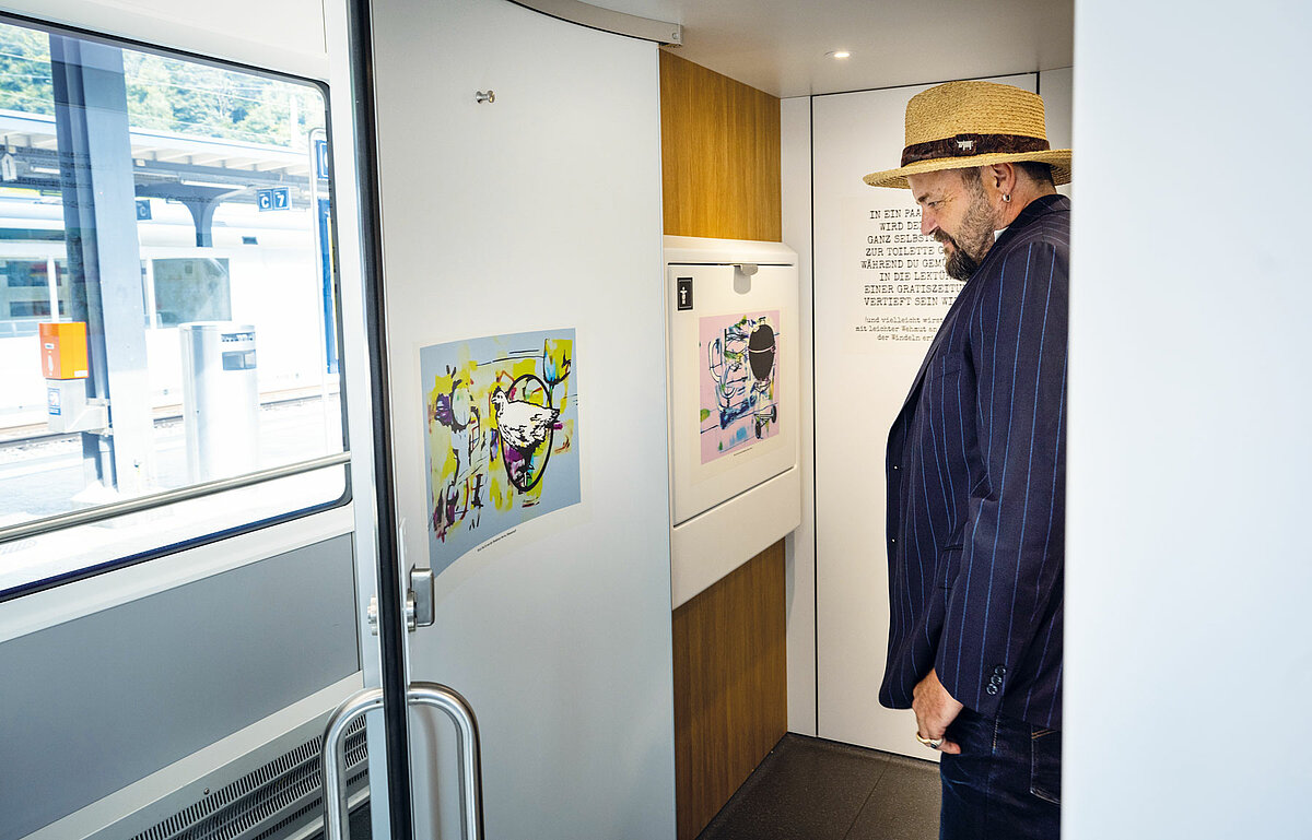 Büne Huber sieht sich die Bilder in der Zugtoilette an. Sein künstlerischer Lieblingsort.