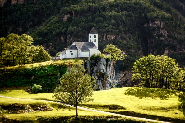 Die Kirche San Martino umgeben von grüner Landschaft.